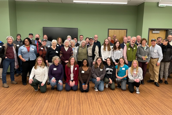 Large group photo of members facing the camera after voting to merge